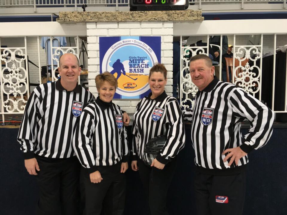 Referees posing in front of Mite Beach Bash poster