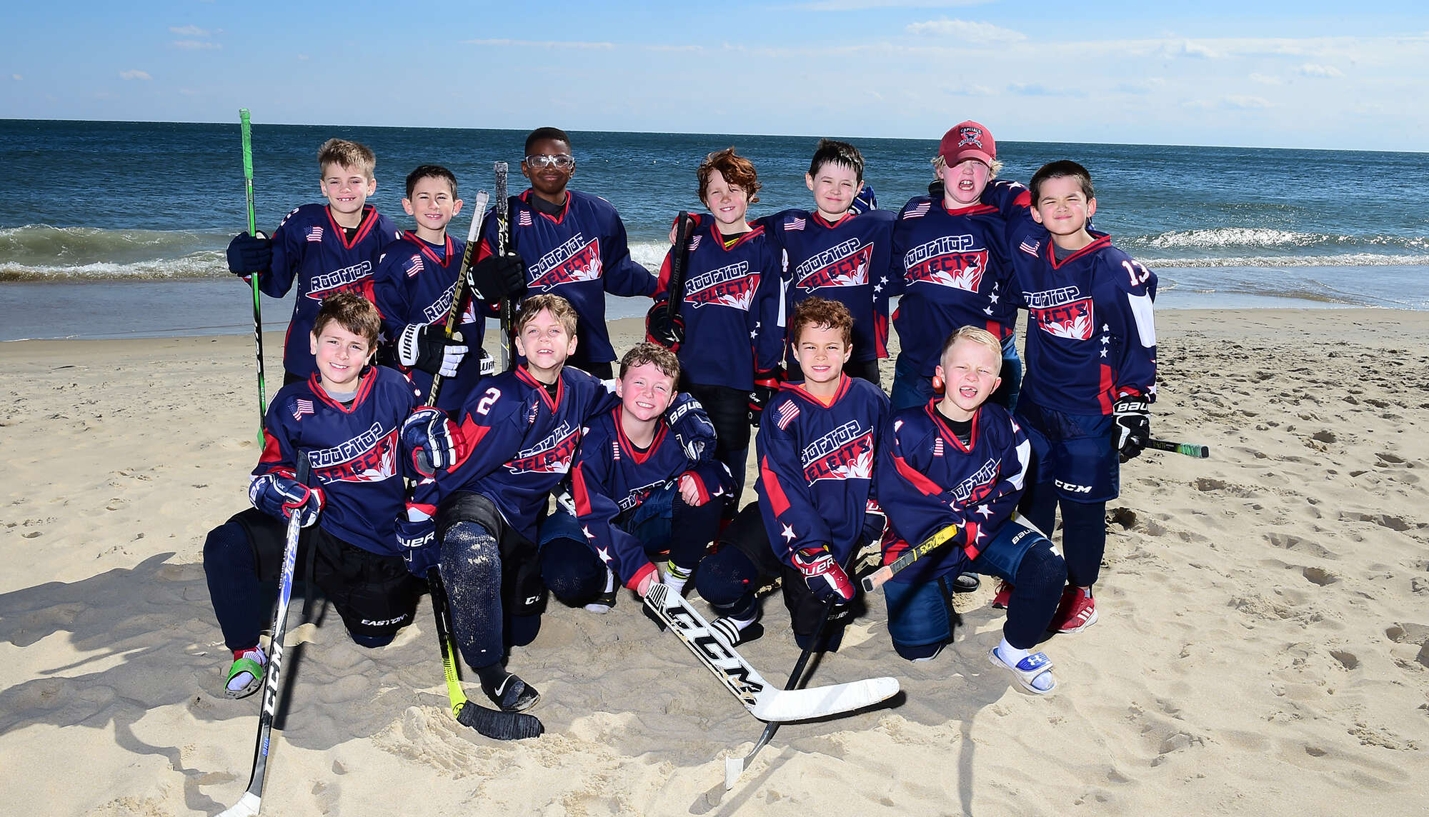 Children hockey team posing on the beach